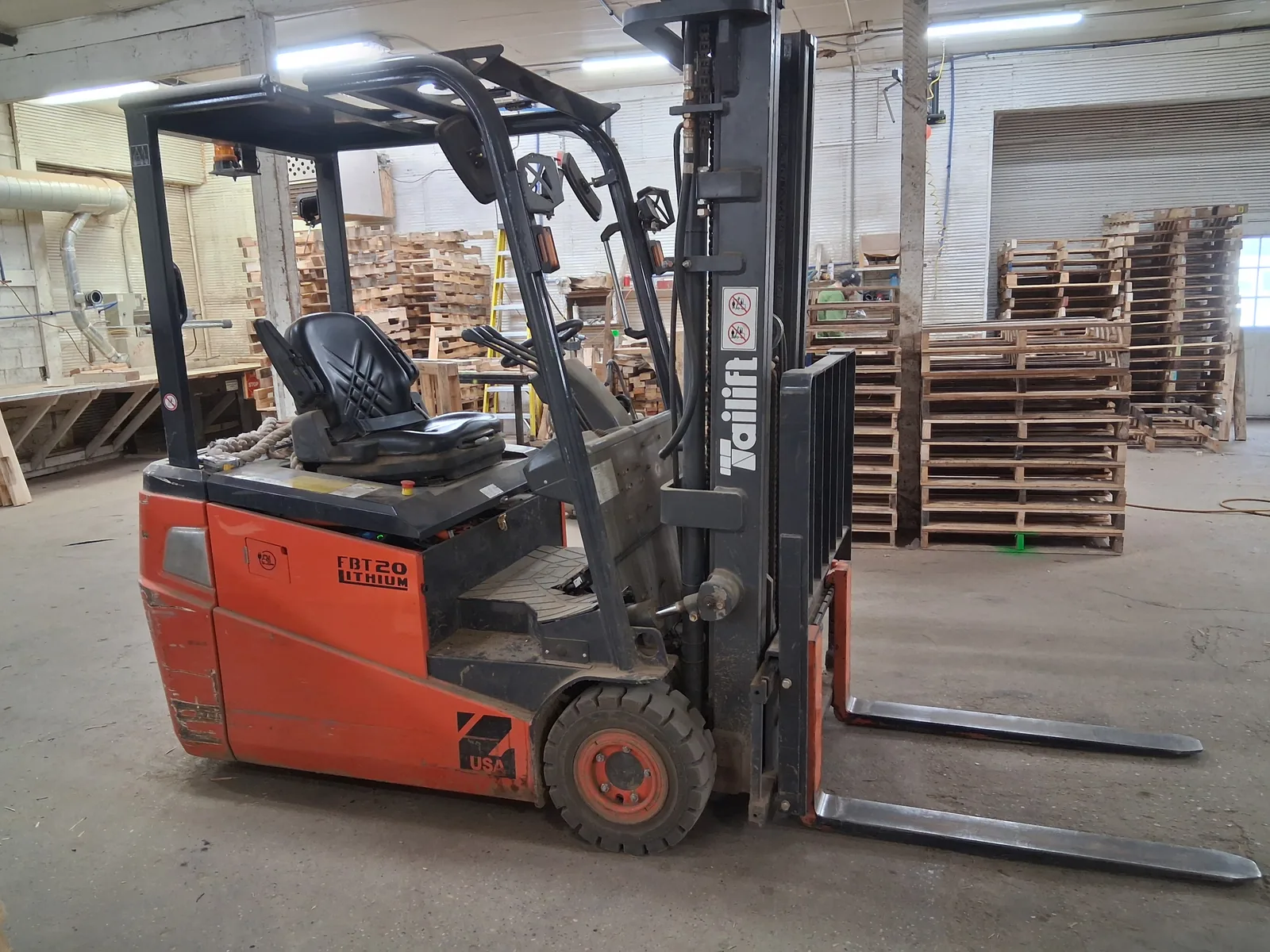 Forklift moving stacked pallets